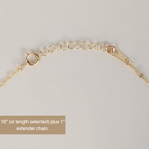 May include: Close-up of a gold-colored necklace with a delicate chain and a lobster clasp. The necklace includes an extender chain. Text on the image reads: "16" (or length selected) plus 1" extender chain."