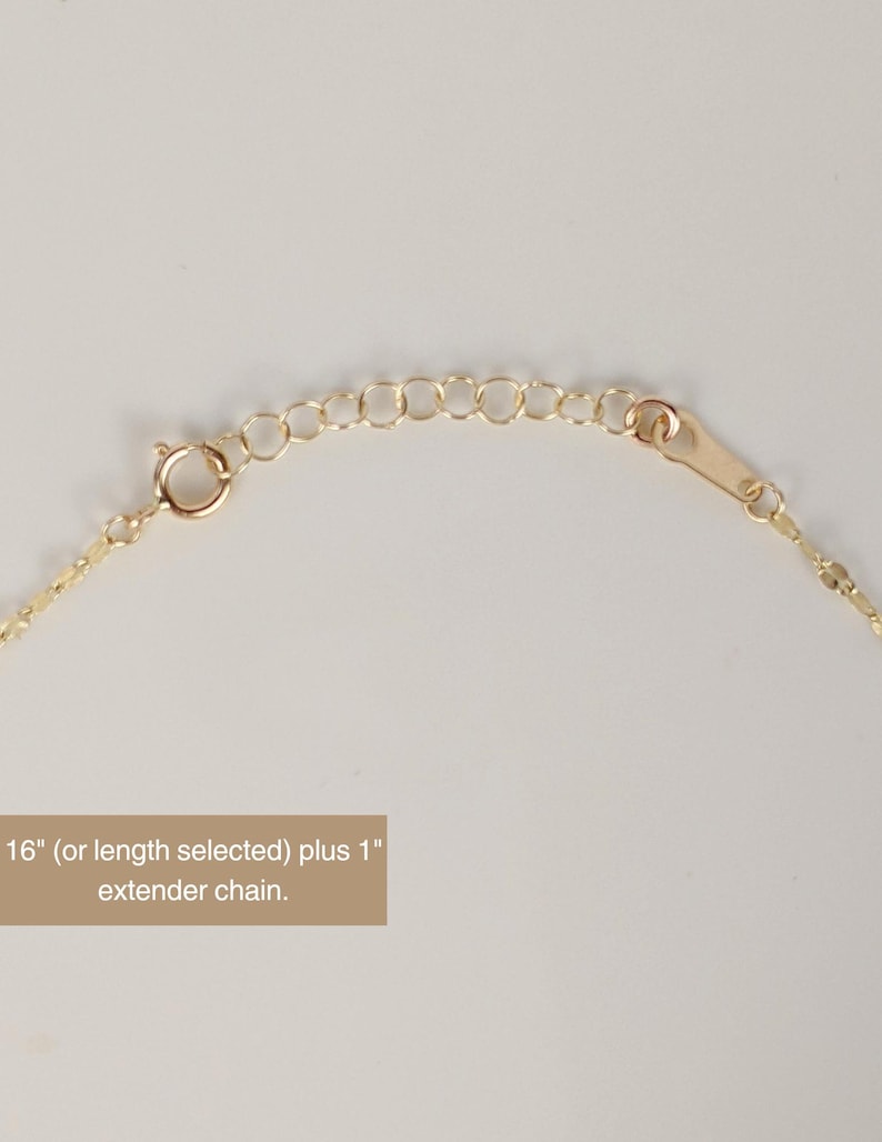 May include: Close-up of a gold-colored necklace with a delicate chain and a lobster clasp. The necklace includes an extender chain. Text on the image reads: "16" (or length selected) plus 1" extender chain."