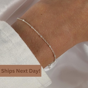 May include: A delicate silver bracelet with small, evenly spaced beads and a fine chain. The bracelet is worn on a wrist, with a white fabric in the background. The text "Ships Next Day!" is visible.