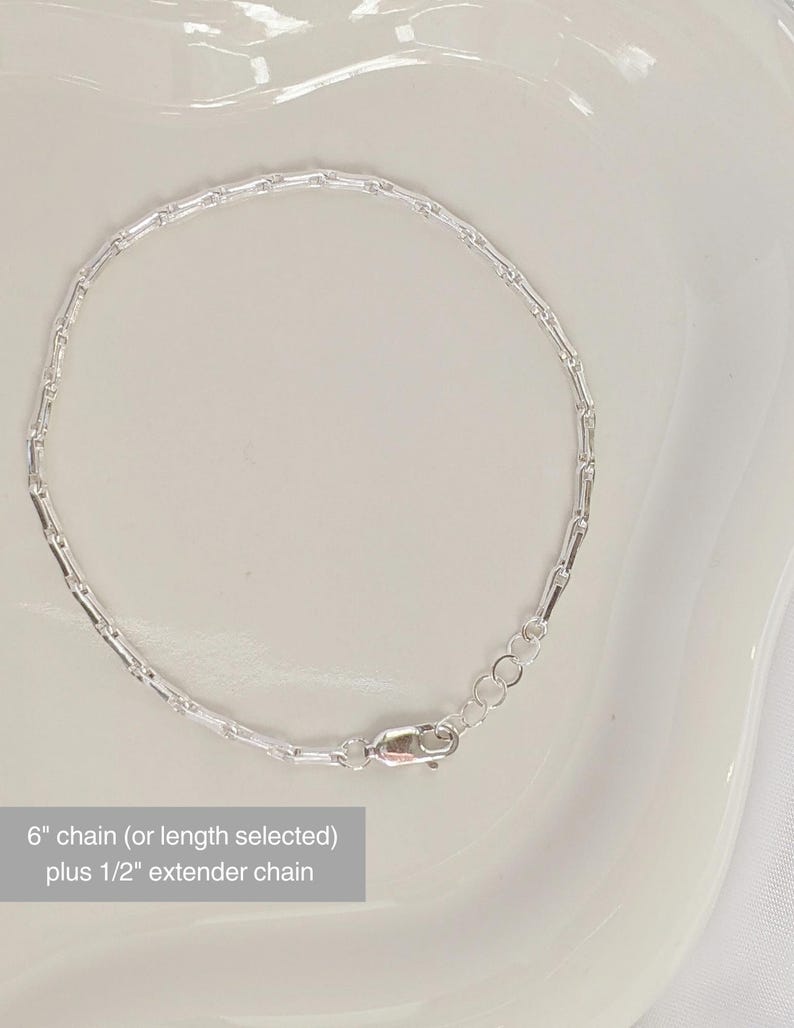 Puede incluir: Un brazalete de cadena de plata con cierre de langosta. La cadena mide 15,24 cm de largo con una cadena extensora de 1,27 cm.