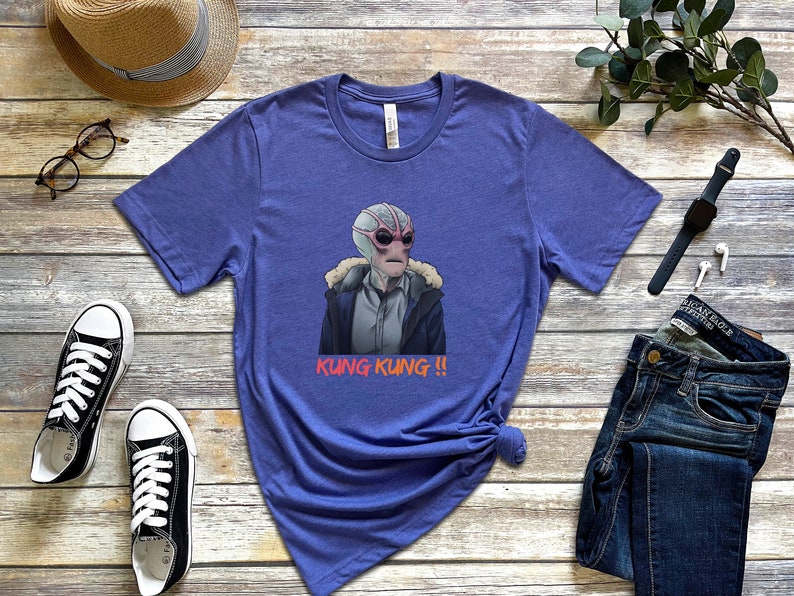 May include: A purple t-shirt with a graphic of an alien wearing a jacket and the text "Kung Kung!!" printed on it.