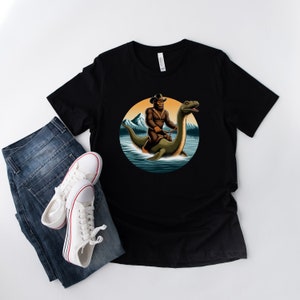 Bigfoot riding loch ness monster in a lake Shirt Sasquatch Shirt Hilarious Bigfoot Shirt Unique T-Shirt Joke tee gift idea Cool T shirt