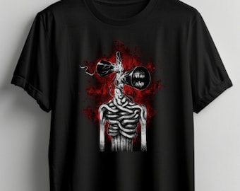 May include: Black t-shirt featuring a white graphic of a creepy, long-necked creature with a pair of black, phone-like objects for a head. The creature is surrounded by a red, splatter-like background.