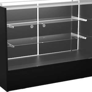 May include: A black display case with glass panels and shelves. The case has a rectangular shape with a solid black base and frame. The interior features multiple clear glass shelves supported by metal brackets, suitable for showcasing items.