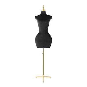 May include: A black velvet dress form with a gold-colored adjustable stand. The dress form has a classic hourglass shape and a gold finial at the top. The base of the stand is a four-point star.