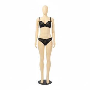 May include: A black lace bra and matching underwear set displayed on a mannequin. The lingerie features delicate floral lace detailing. The mannequin is a neutral skin tone and stands on a black base against a white background.