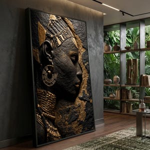 May include: A large rectangular wall art piece featuring a textured, high-relief profile portrait of a person with dark skin, adorned with intricate gold-colored jewelry including a headpiece, large circular earrings, and a wide, layered neck collar.