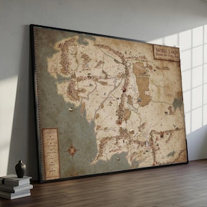 May include: Framed map of Middle Earth during the Third Age, with detailed geographical features in shades of brown, beige, and green. The map includes text labels and a legend, presented in a black frame.