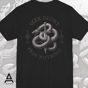 May include: Black t-shirt featuring a detailed graphic of a serpent coiled around a sword. The text "SEEK GLORY FEAR NOTHING" is arched above and below the image. The Alethia Co. logo is at the bottom.