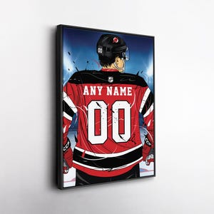 May include: Framed artwork of a hockey player from the back, wearing a red and black jersey with the number "00" and the text "ANY NAME". The player is wearing a black helmet and is on the ice.