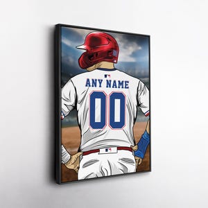 May include: A framed illustration of a baseball player from the back, wearing a white jersey with the text "ANY NAME" above the number "00" in blue. The player wears a red helmet and blue wristbands, set against a stadium backdrop.