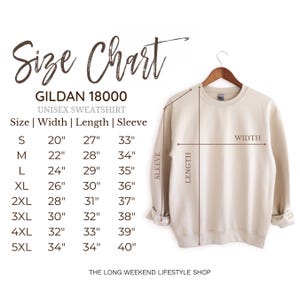 May include: A beige Gildan 18000 unisex sweatshirt hangs on a wooden hanger. The image includes a size chart with measurements for width, length, and sleeve length in inches, ranging from size S to 5XL. The text "Size Chart" is at the top.
