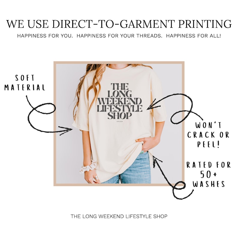 May include: Cream-colored t-shirt with the text "THE LONG WEEKEND LIFESTYLE SHOP" in black. The image highlights the soft material and direct-to-garment printing, promising durability with 50+ washes. The shirt is paired with blue jeans.