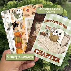 Puede incluir: Cinco insertos rectangulares imprimibles para Kindle con temas de otoño y fantasmas. Los diseños incluyen fantasmas leyendo libros, calabazas, gatos negros y escenas interiores acogedoras. Un inserto muestra el texto Just One More Chapter.