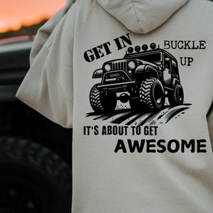 May include: A white hoodie with a black graphic of a jeep on the back. The graphic says "Get in... Buckle Up. It's about to get Awesome".