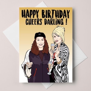 May include: Greeting card with the text "HAPPY BIRTHDAY CHEERS DARLING!" featuring illustrations of two women holding champagne flutes. One woman wears a black cap and jacket, the other a zebra-print jacket.