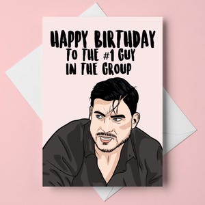 Peut inclure: Carte d'anniversaire avec le texte "HAPPY BIRTHDAY TO THE #1 GUY IN THE GROUP" en noir gras. La carte présente une illustration d'un homme aux cheveux foncés et à la barbe, portant une chemise noire, sur fond rose.