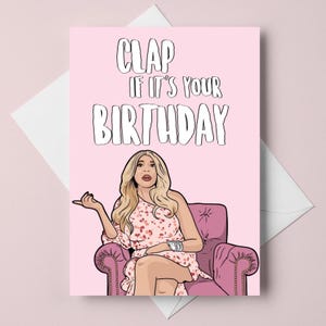 Peut inclure: Carte d'anniversaire rose avec le texte "CLAP IF IT'S YOUR BIRTHDAY" en blanc. La carte présente une illustration d'une femme en robe à fleurs roses assise dans un fauteuil rose. La femme fait un geste de la main.