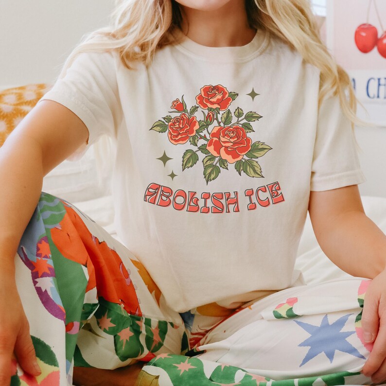 Ivory cropped Comfort Colors tee with floral message worn by woman in colorful printed pants