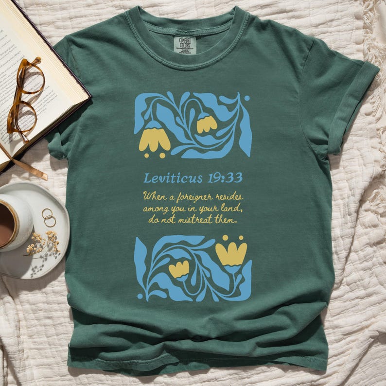 Green Comfort Colors T-shirt with Matisse floral scripture art and yellow tulips, styled with coffee and glasses