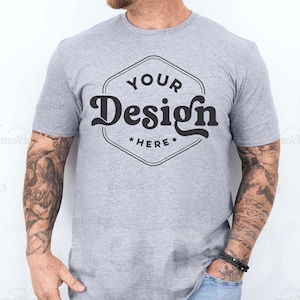 Peut inclure: Un t-shirt gris avec un motif noir qui dit "Your Design Here" dans une police rétro.