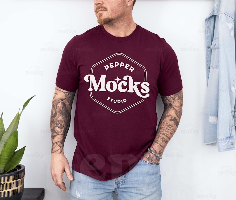 Pode incluir: Uma camiseta vinho com um logotipo branco que diz "Pepper Mocks Studio" em uma fonte retr&ocirc;.