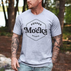 Bella Canvas 3001 Athletic Heather T-shirtmodel | 3001 mock-up heren-T-shirt | Nepmodel echt mannelijk model | Natuur buiten | Mockup voor Vaderdag