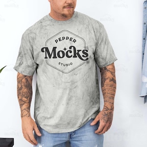 Puede incluir: Una camiseta gris claro con un aspecto desgastado que presenta un logotipo negro que dice "Pepper Mocks Studio".