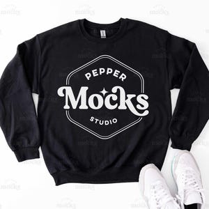 Könnte beinhalten: Schwarzer Pullover mit einem weißen Logo, auf dem "Pepper Mocks Studio" in einer Retro-Schrift steht.
