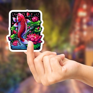 May include: A sticker featuring a colorful illustration of a red and white koi fish swimming in a pond with pink lotus flowers and green lily pads.