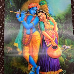 May include: A painting of a blue-skinned man playing a flute with a woman standing beside him. The man is wearing a yellow and blue robe and a peacock feather headdress. The woman is wearing a purple and orange sari and holding a clay pot.