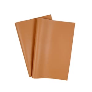 Puede incluir: Dos hojas de cuero marrón, dobladas por la mitad y apiladas una encima de la otra.