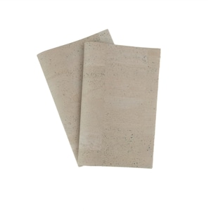Op de afbeelding: Twee vellen beige kurk stof met een gespikkelde textuur.