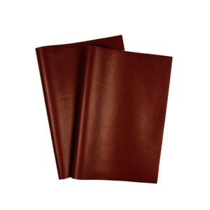 Peut inclure: Deux feuilles de papier de soie brun foncé, légèrement superposées, sur fond blanc. Le papier a une finition lisse et mate et est plié pour montrer la texture. Idéal pour l'emballage cadeau ou le bricolage.