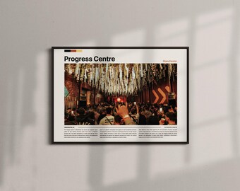 May include: Framed poster featuring the words "Progress Centre" with a crowd of people gathered in a large room. The poster has a black frame and is hanging on a white wall. The word "Manchester" is also visible.