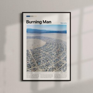 May include: Framed poster depicting an aerial view of the Burning Man festival in Nevada. The poster is in a black frame and includes the text "Burning Man" and "Nevada". The image shows the desert landscape and the temporary city layout.