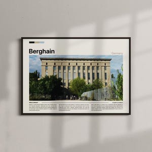 May include: Framed print of the Berghain building in Berlin, Germany. The image shows the exterior of the building with a beige facade, numerous windows, and surrounding trees. The word "Berghain" is printed in bold black letters.