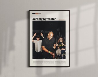 May include: A framed poster featuring a photograph of Jeremy Sylvester performing at a club. The poster has a black frame and a cream-colored border. The text "Jeremy Sylvester" is at the top, with additional text below the image.