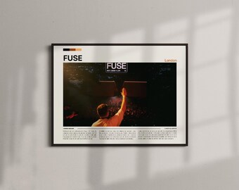 May include: Framed poster with the word "FUSE" at the top, and the word "London" to the right. The image shows a person with their arm raised towards two square shapes. The poster has a black frame and is hanging on a white wall.