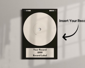 May include: A framed record display with a cream-colored vinyl record. The black frame has a label that reads "Your Record 1999 Record Label." The text "Insert Your Record" is also visible.