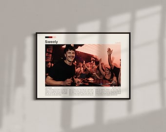 May include: Framed poster featuring a photograph of a man smiling in front of a crowd at a music event. The word "Sweely" is at the top, with "Leeds" below it. The image has a warm, reddish hue.