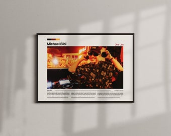 May include: A framed poster featuring a photograph of a DJ wearing sunglasses and headphones. The poster has the text "Michael Bibi" and "One Life" in the upper section. The DJ is in front of a DJ mixer. The poster has a black frame.
