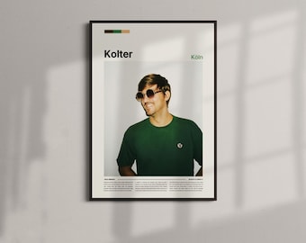 May include: A framed poster featuring a smiling person wearing sunglasses and a green t-shirt. The poster has the name "Kolter" and the city "Köln" printed on it. The poster is in a black frame and is hanging on a white wall.