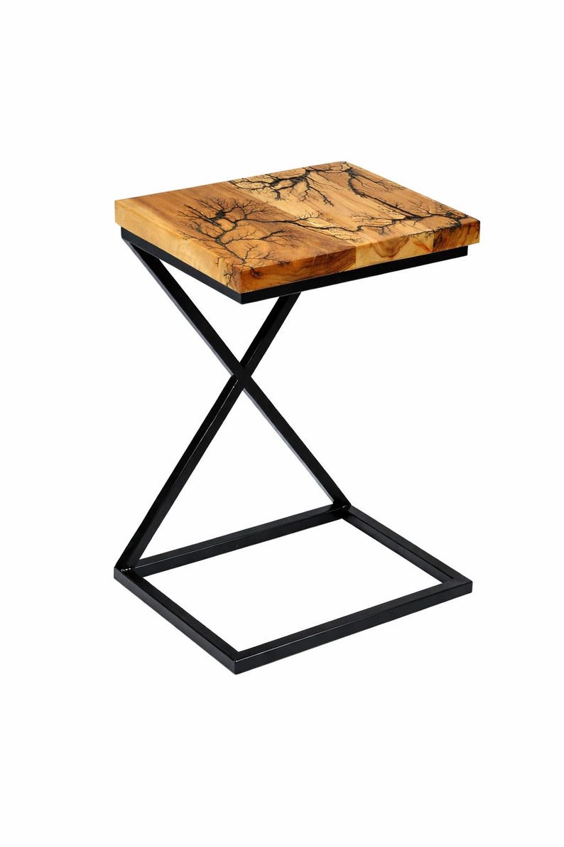 May include: A square side table with a natural wood top featuring a unique, lightning-like pattern. The tabletop is supported by a black, geometric metal frame. The table is designed for indoor use.