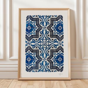 May include: A rectangular wall art print in a light wood frame featuring a repeating pattern of blue and black ornate floral and geometric motifs on a cream background. The word sofia is printed in small, thin, black script in the bottom right.