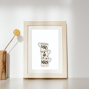 Può includere: Una tazza in ceramica bianca con la scritta "MR & MRS" in nero, impilata su altre due tazze con pois colorati.