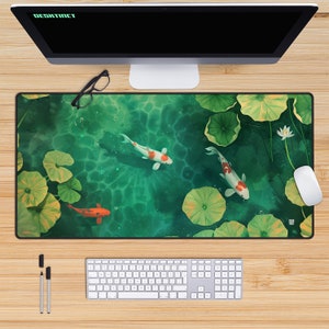 May include: Rectangular desk mat featuring a serene pond scene with koi fish, lily pads, and a white lotus flower. The mat has a green and blue water background. A computer, keyboard, mouse, pens, and glasses are on a wooden desk.