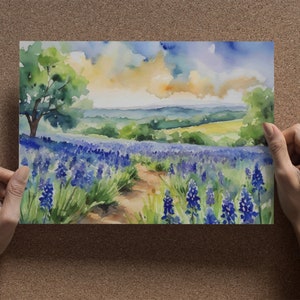 May include: Watercolour painting of a field of purple flowers with a path leading through the centre. The background features a green hillside and a blue sky with white clouds.