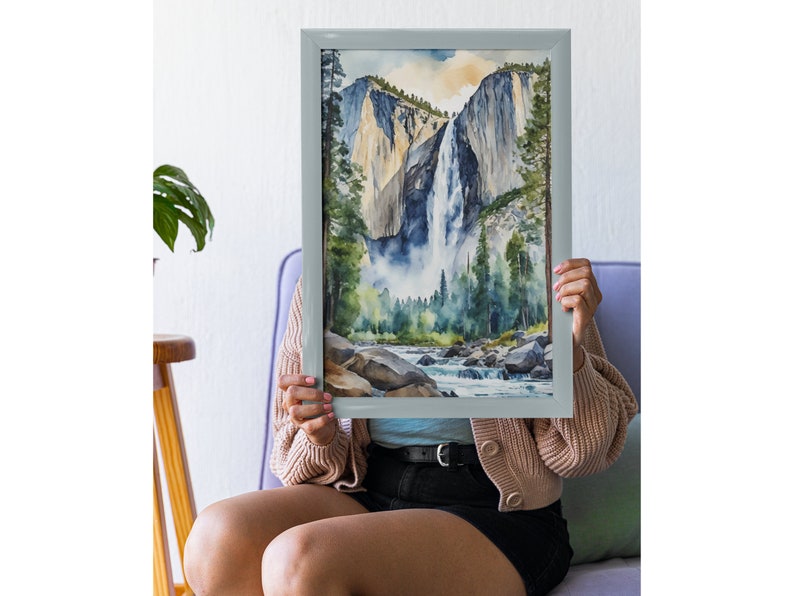 May include: A framed watercolor painting of a waterfall cascading down a mountainside. The painting features a blue sky, green trees, and a river flowing through the valley.