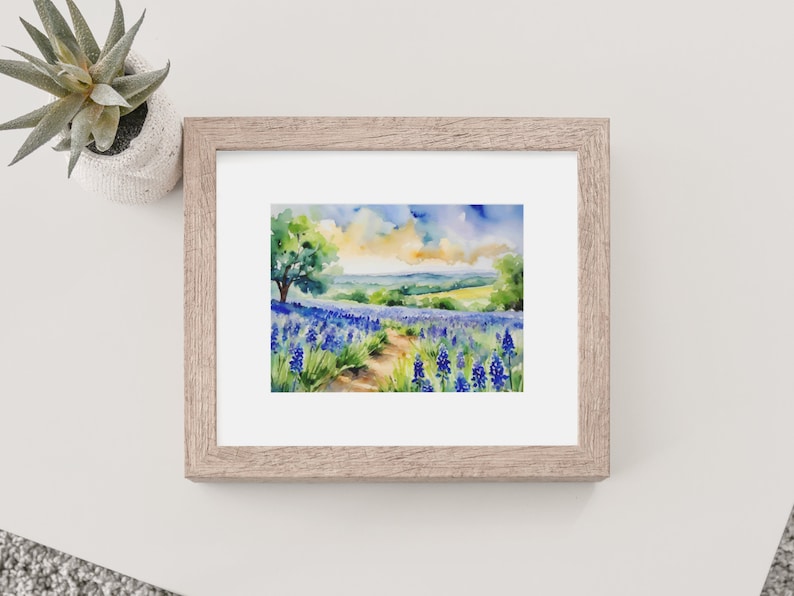 May include: Watercolour painting of a field of bluebonnet flowers with a dirt path leading through the field. A lone tree stands in the distance, and the sky is a mix of blue, yellow, and white.